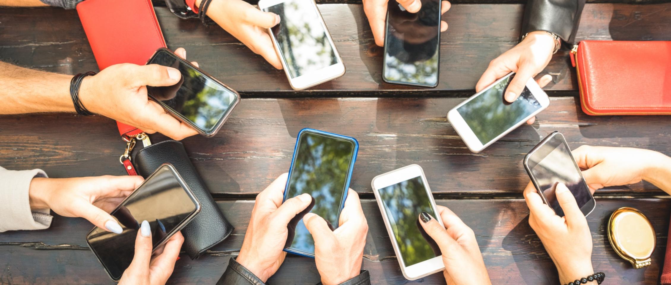 Viele_Hände_mit_Smartphone_Vogelperspektive