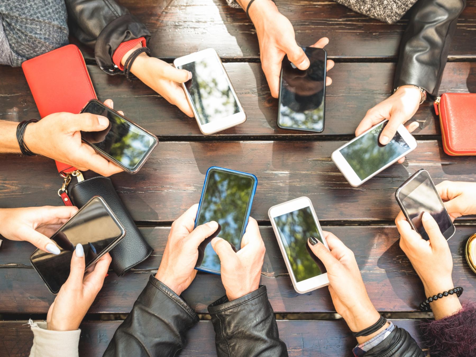 Viele_Hände_mit_Smartphone_Vogelperspektive