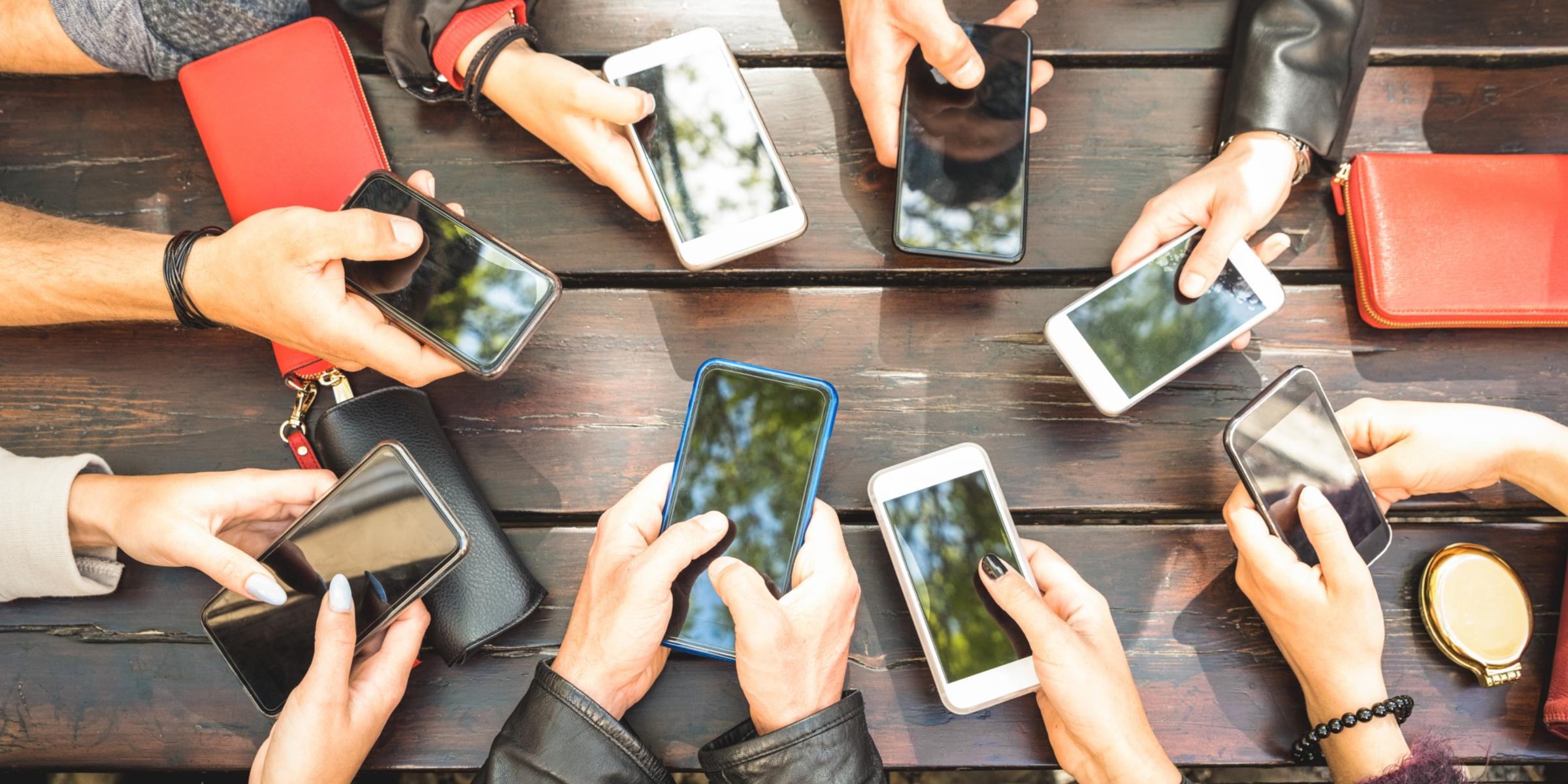 Viele_Hände_mit_Smartphone_Vogelperspektive