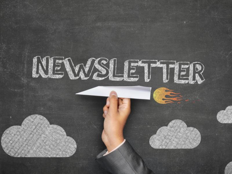 Papierflugzeug vor einer Tafel mit dem Text 'Newsletter'