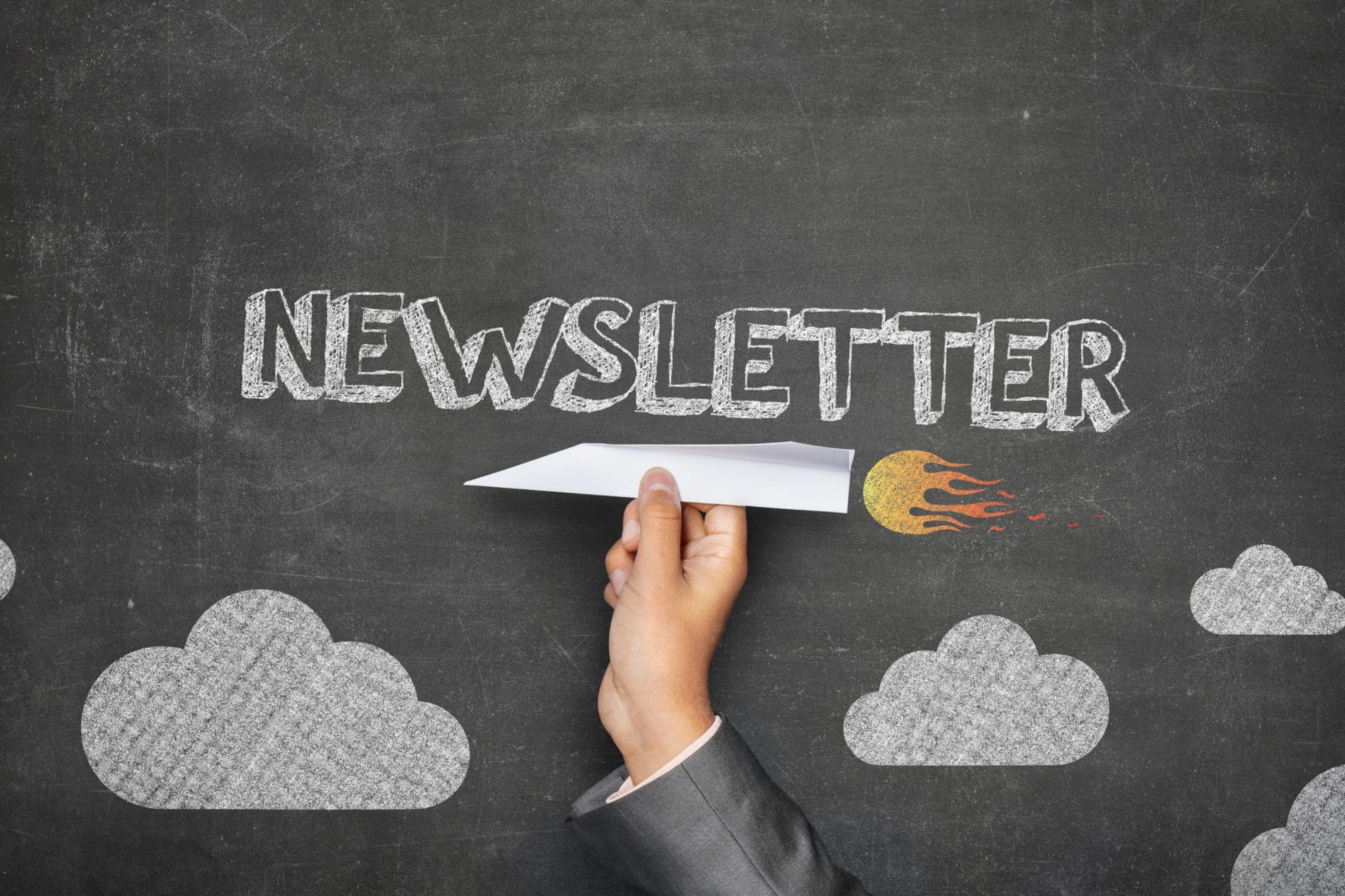 Papierflugzeug vor einer Tafel mit dem Text 'Newsletter'