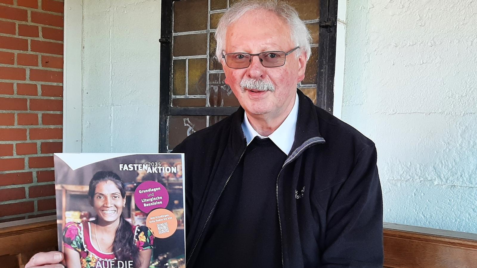 Achim Brennecke, Kreisdechant des Rhein-Erft-Kreises mit dem offiziellen Plakat der diesjährigen Fastenaktion von Misereor.
