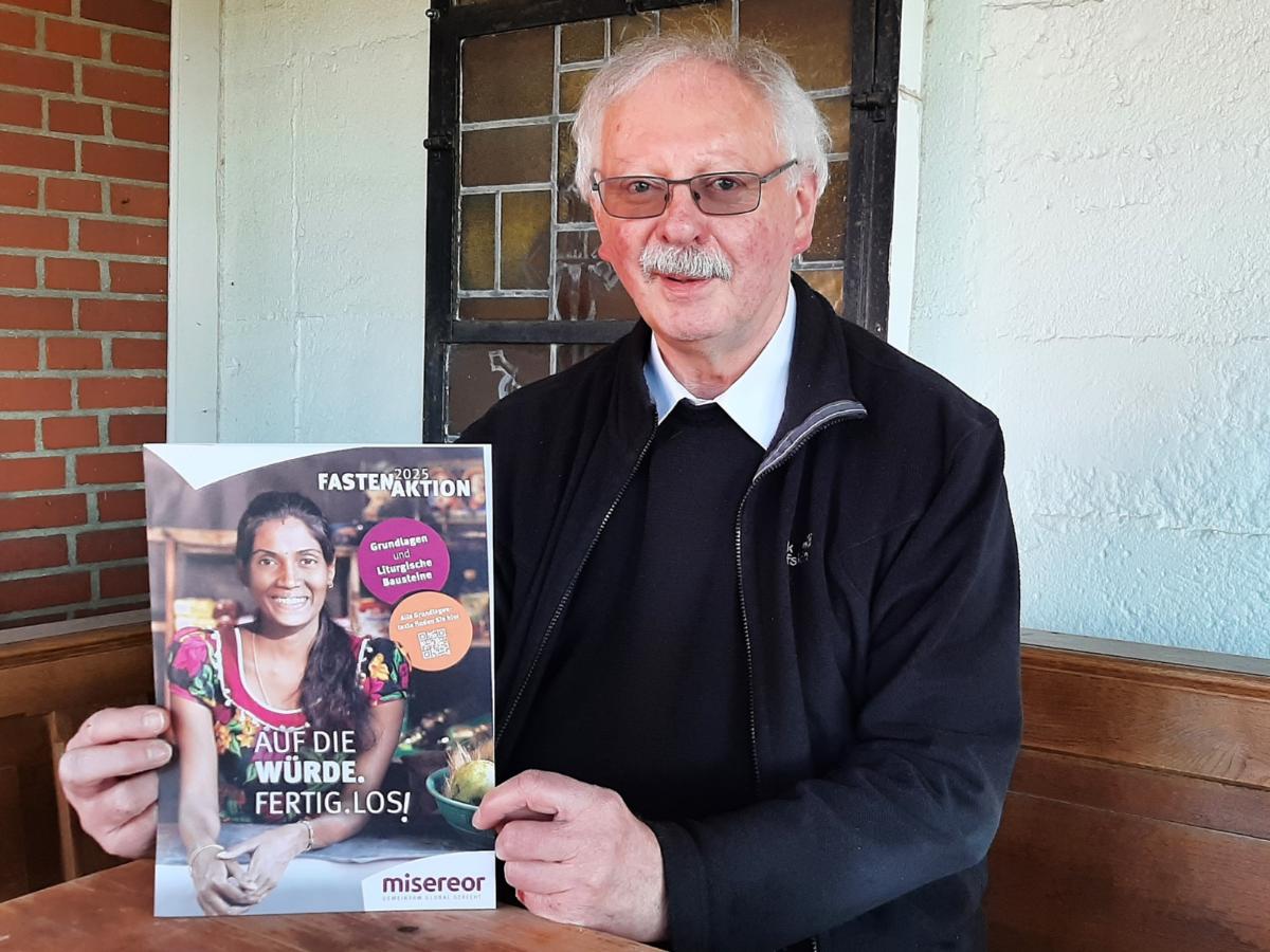 Achim Brennecke, Kreisdechant des Rhein-Erft-Kreises mit dem offiziellen Plakat der diesjährigen Fastenaktion von Misereor.