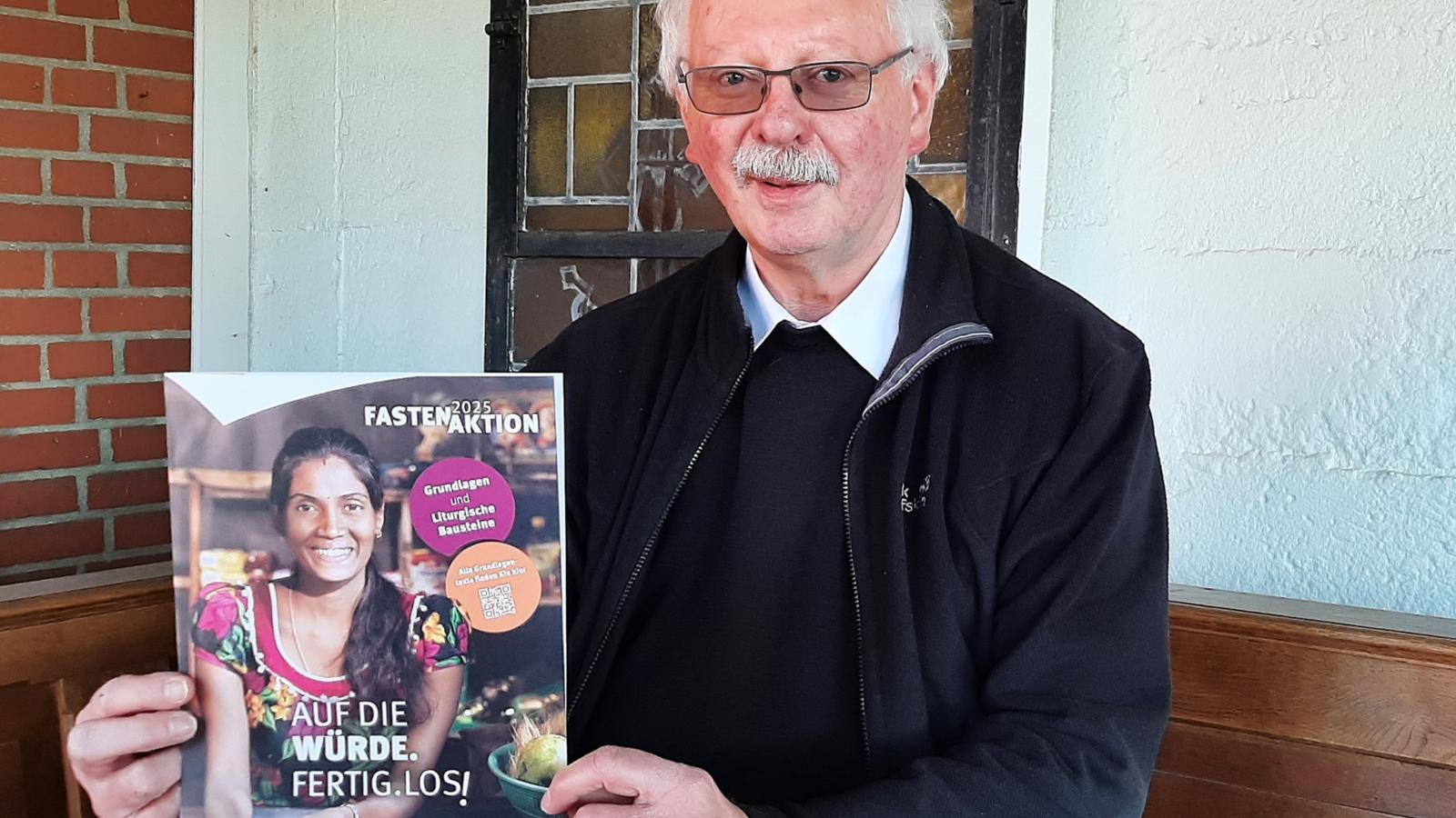 Achim Brennecke, Kreisdechant des Rhein-Erft-Kreises mit dem offiziellen Plakat der diesjährigen Fastenaktion von Misereor.
