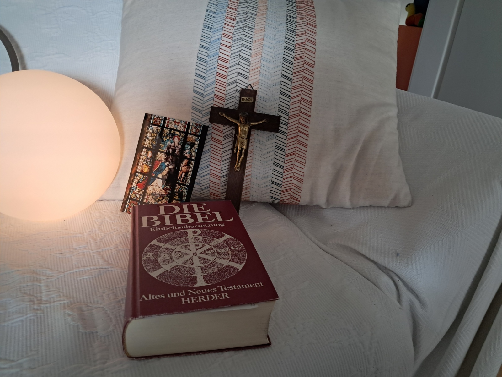 Sofa mit Kissen, Kreuz und Bibel