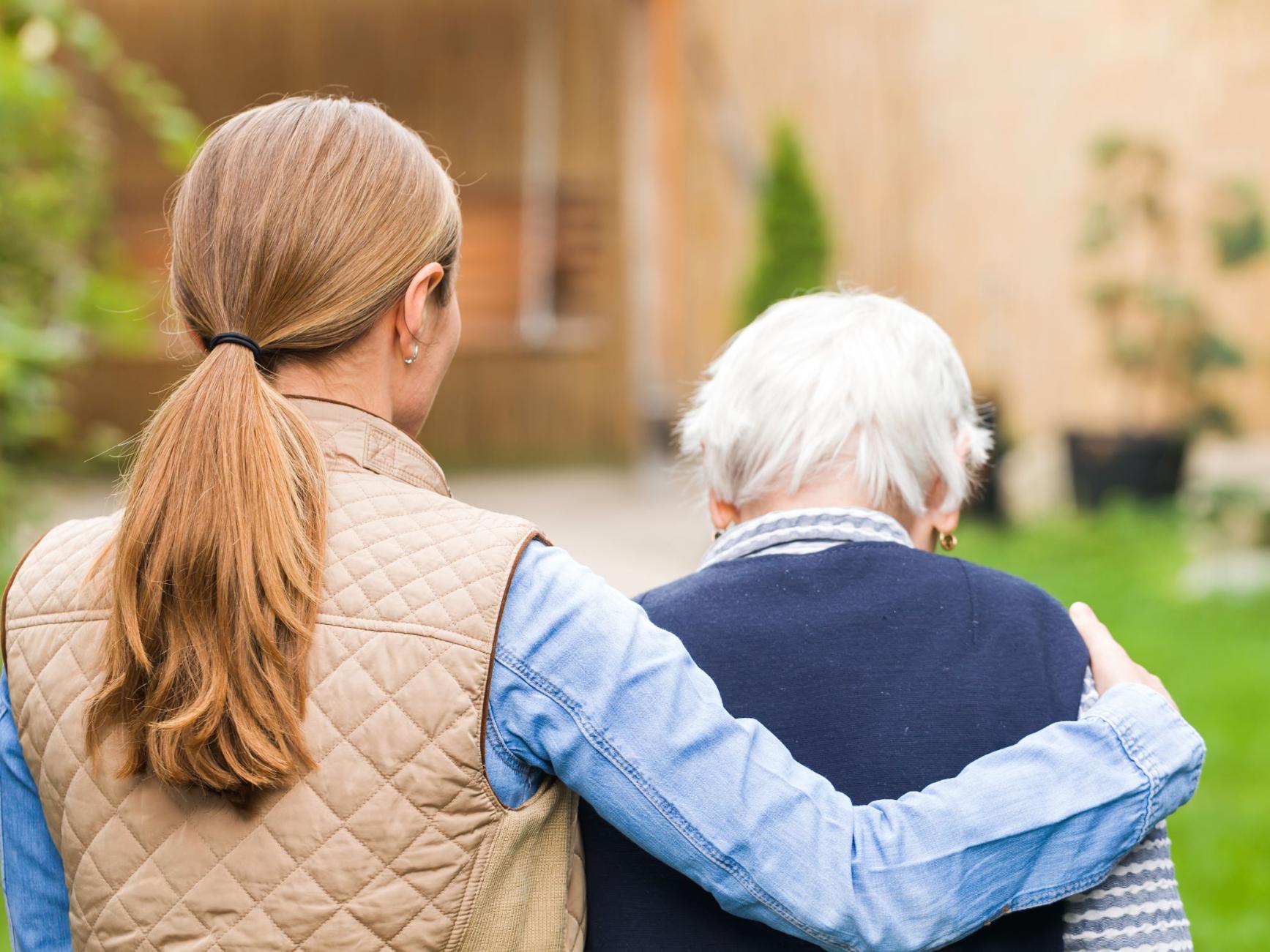 Seniorin und Begleiterin gehen spazieren