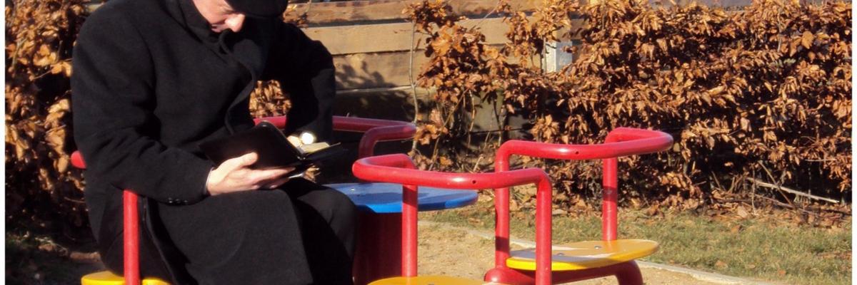 das Alter, Alleinsein, Einsamkeit, alter Mann, ohne Ansprache, in Gedanken versunken,  abwesend sein, in der Sonne sitzen,  lesen,   Kinderkarussell, auf dem Spielplatz,  Fotowettbewerb 2014 Ex-Bild-DB-ID: 12199