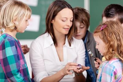 Betreuuerin mit Kindern in Klasse (c) Fotolia / contrastwerkstatt Betreuuerin mit Kindern in Klasse