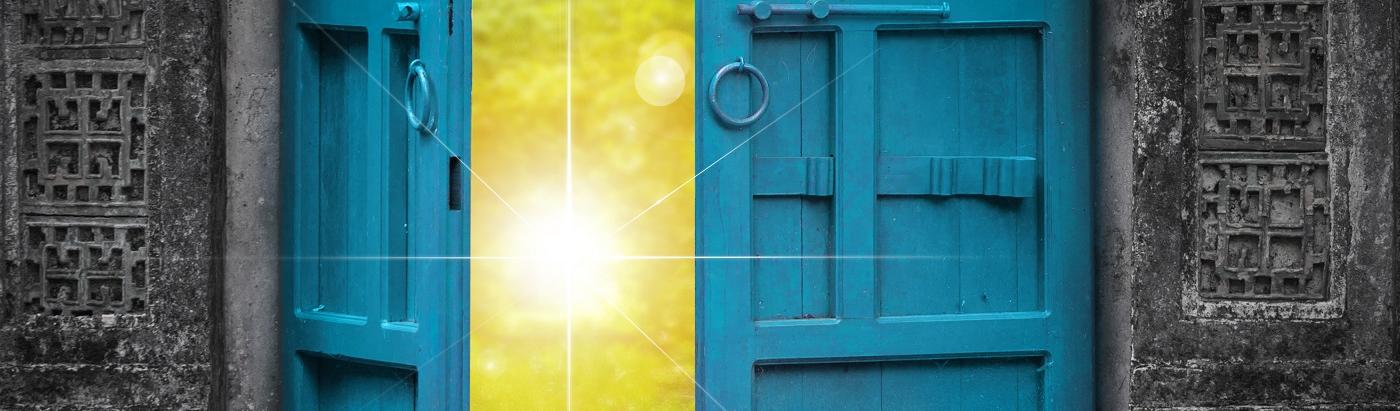 Eine Tür öffnet sich hin auf eine strahlende Sonne.