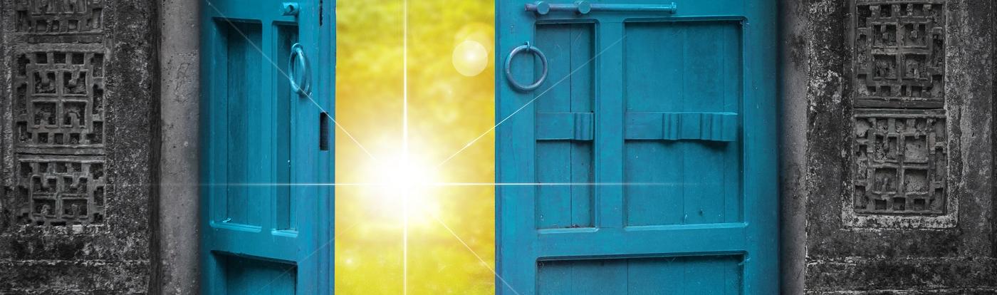 Eine Tür öffnet sich hin auf eine strahlende Sonne.