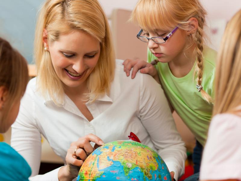 Fotolia-30248298-Kzenon-Betreuerin mit Kindern und Weltkugel-frei