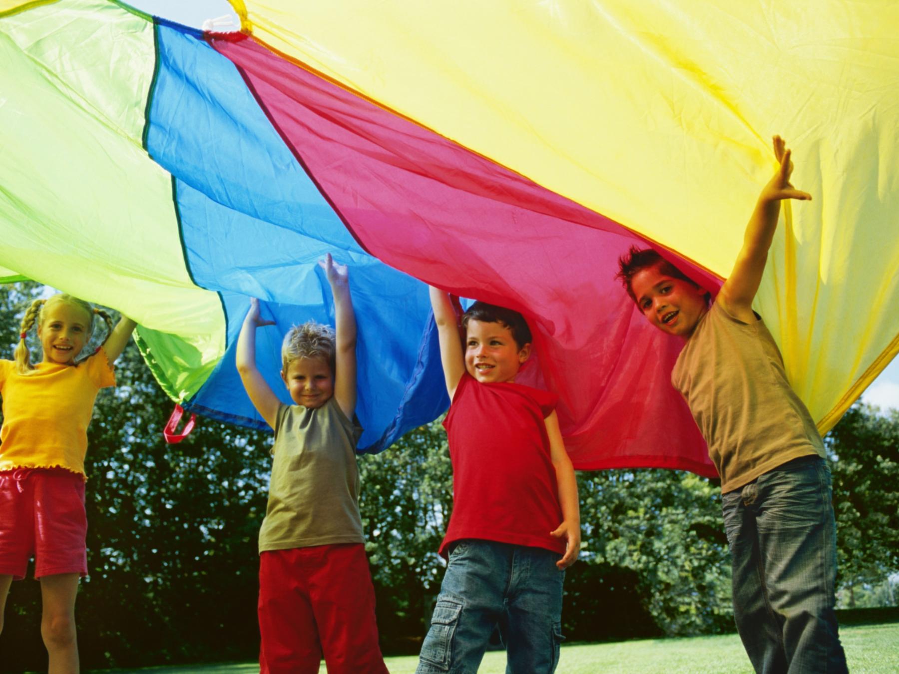 shutterstock_1587849478_Altrendo Images_vier_Kinder_unter_Fallschirm_frei