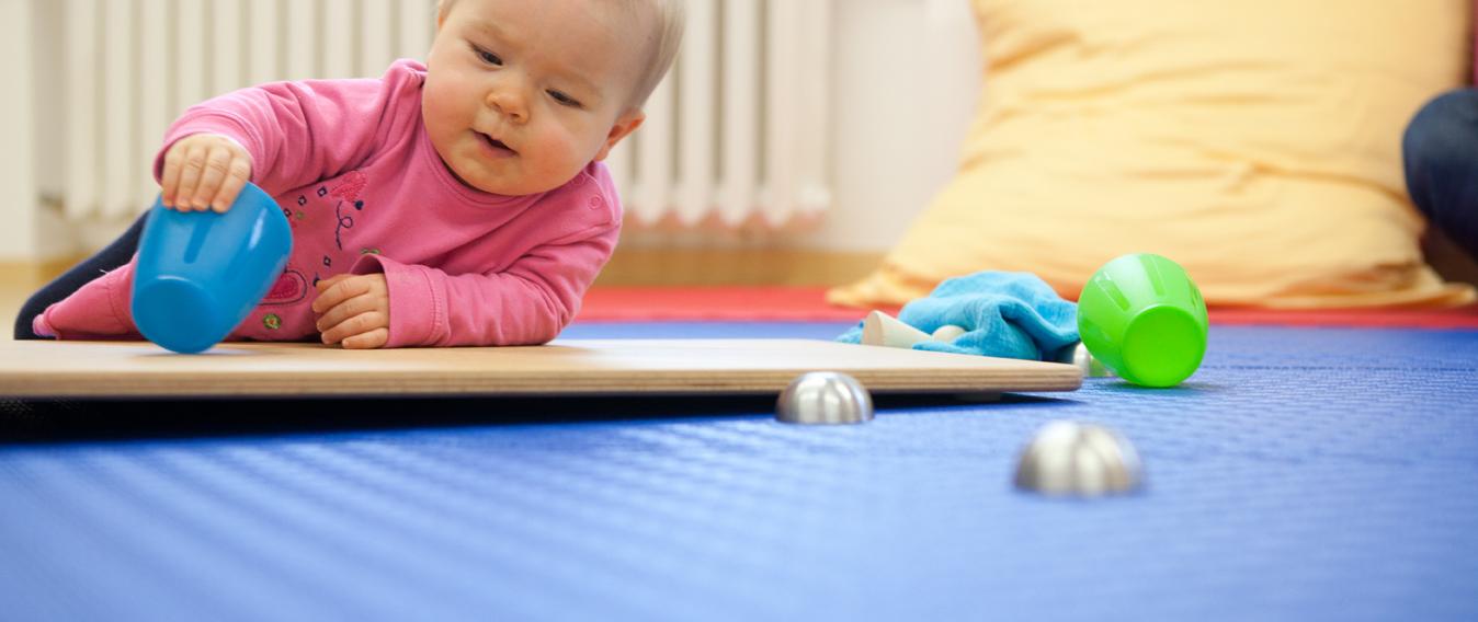 Kleinkind spielt mit Becher