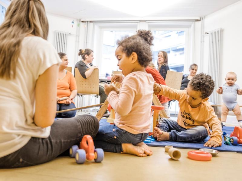 Pikler-Kinder mit Erwachsenen im Kursraum