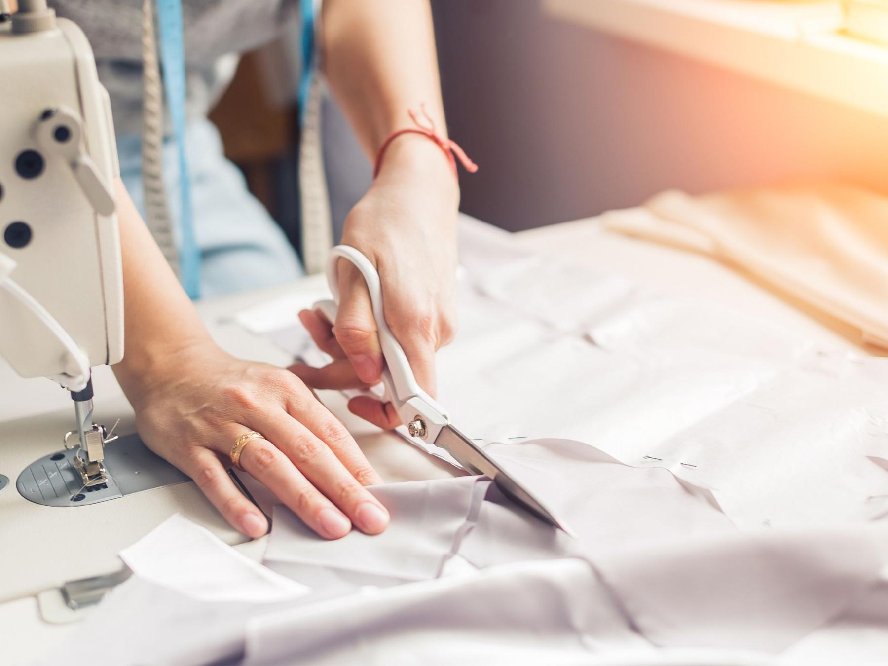 shutterstock_621836930_UfaBizPhoto_Hände_Schere_Nähmaschine_frei