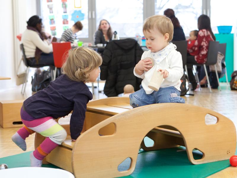 Kinder spielen in einem Eltern-Kind-Kurs auf einem Brückenelement