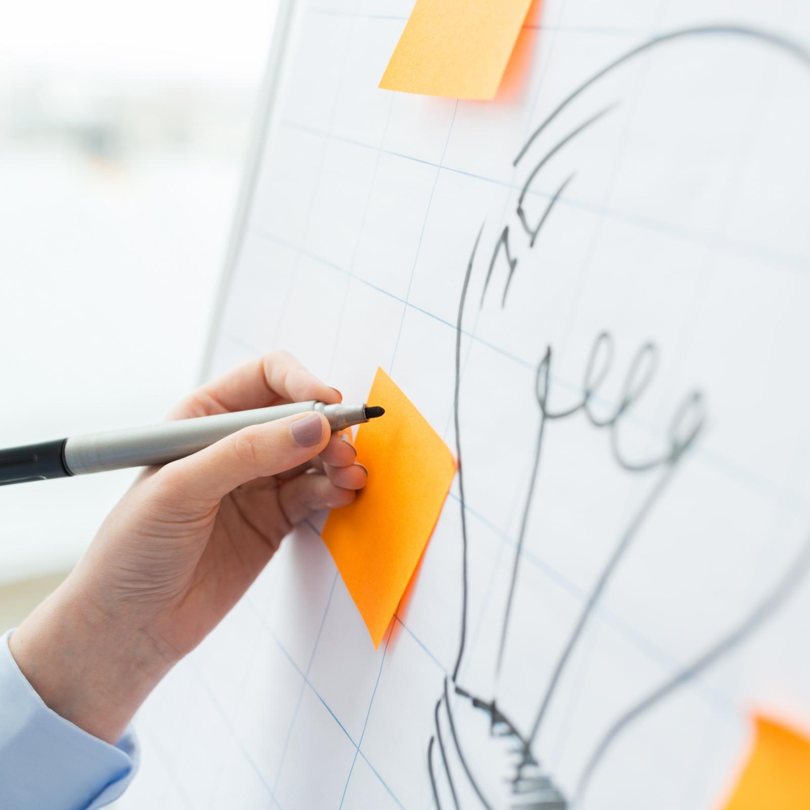 Flipchartzeichnung mit Glühbirne und Post-its